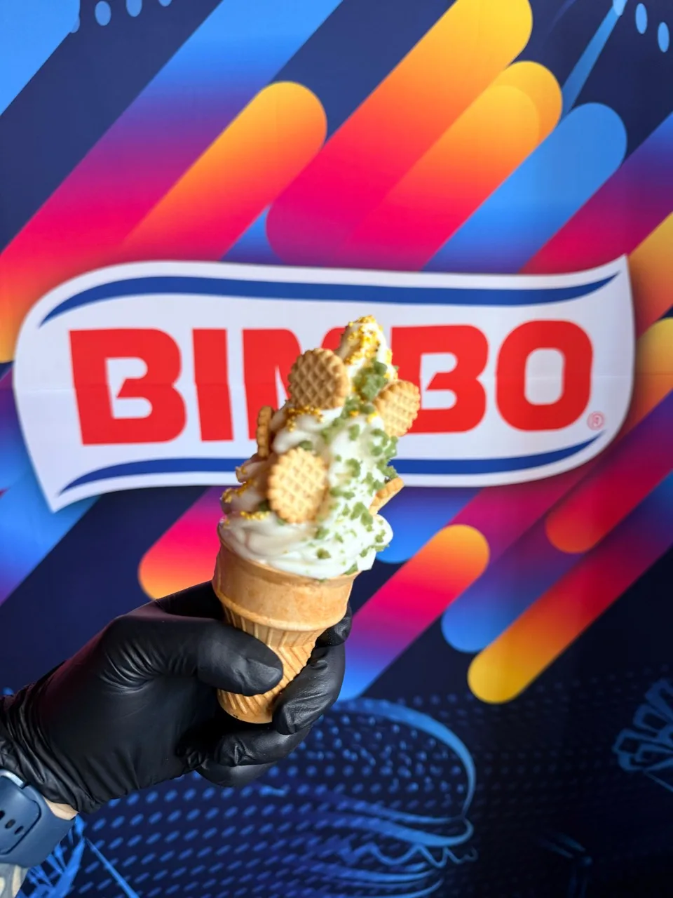 Cono de helado con galletas y complementos frente al logotipo de Bimbo